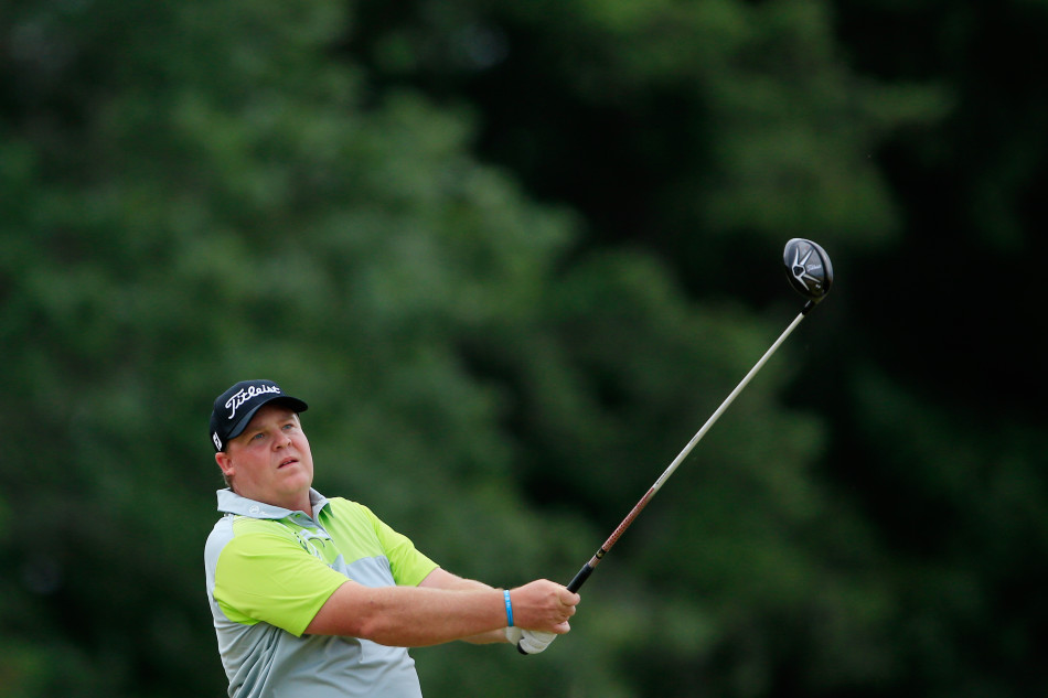 科特-巴恩斯在开阔的球场上完成大幅度的收杆动作，背景是蓝天绿树，画面充满张力。