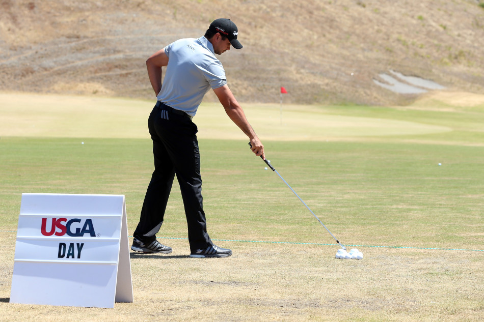 戴伊弯腰蹲在球道边审视球位，利用这短暂的时刻稍作休息，调整呼吸