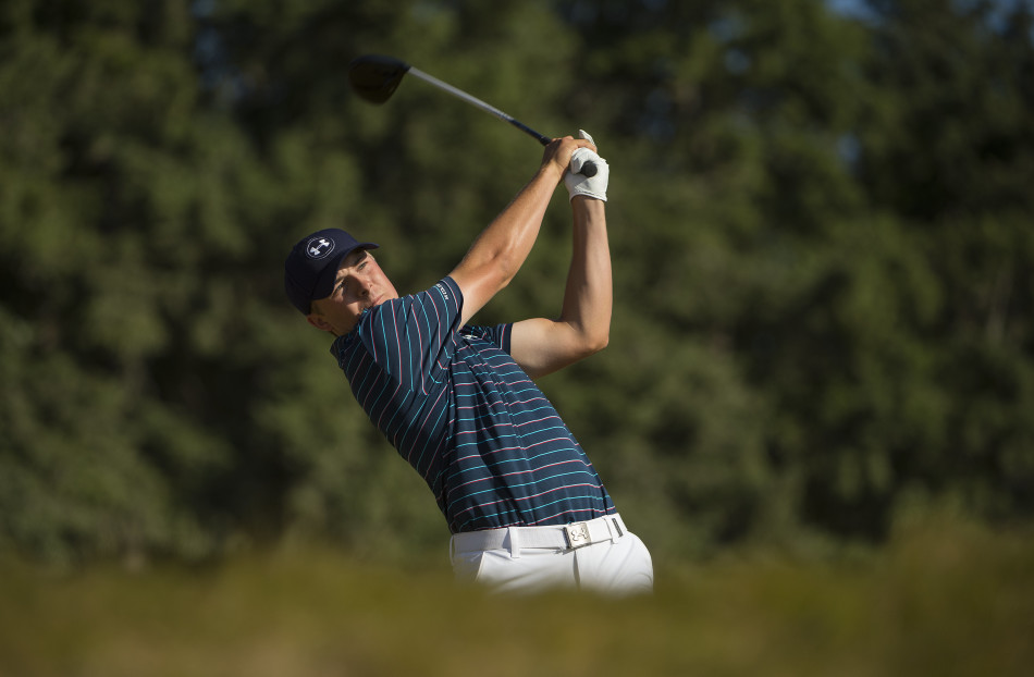 乔丹·斯皮思在钱伯斯湾第18洞果岭上，以一记精准的推杆锁定胜局后，振臂向欢呼的观众致意。