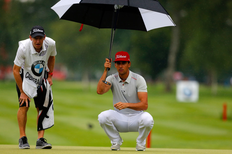 詹姆斯·莫里森与他的球童并肩半蹲在果岭边，两人目光如炬，共同凝视着推杆线路上的细微起伏，仿佛在无声地交换着对下一杆的精确计算。