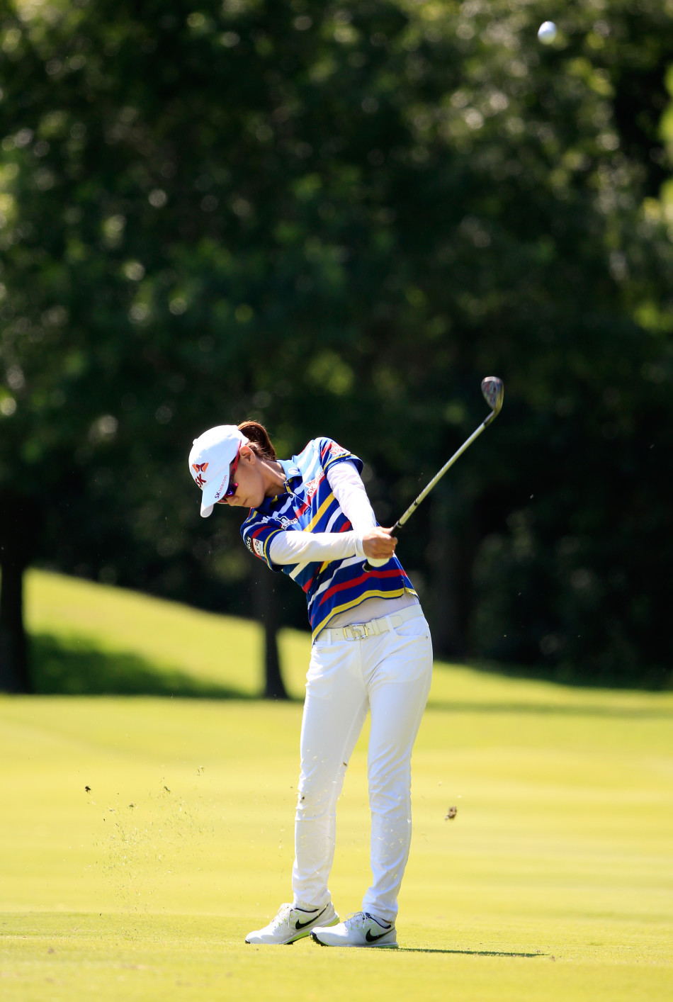 崔罗莲与球童在球道上并肩行走，认真讨论下一杆的策略