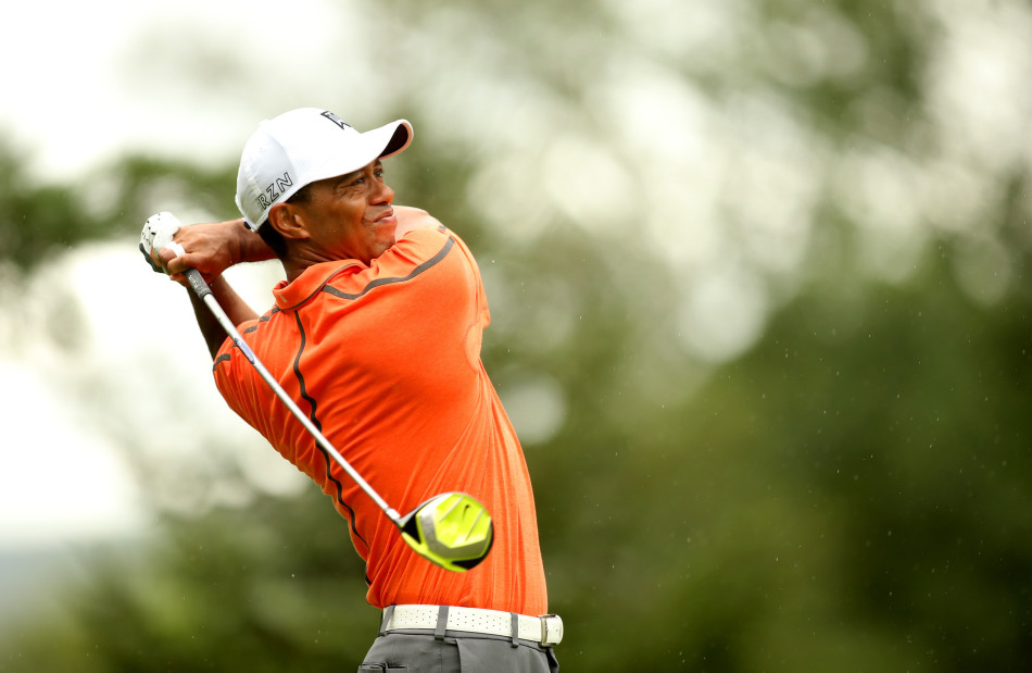 泰格·伍兹站在钱伯斯湾球场的沙坑中,眉头紧锁,凝望高悬于长草之上的小球,阳光将他孤独的身影拉长。