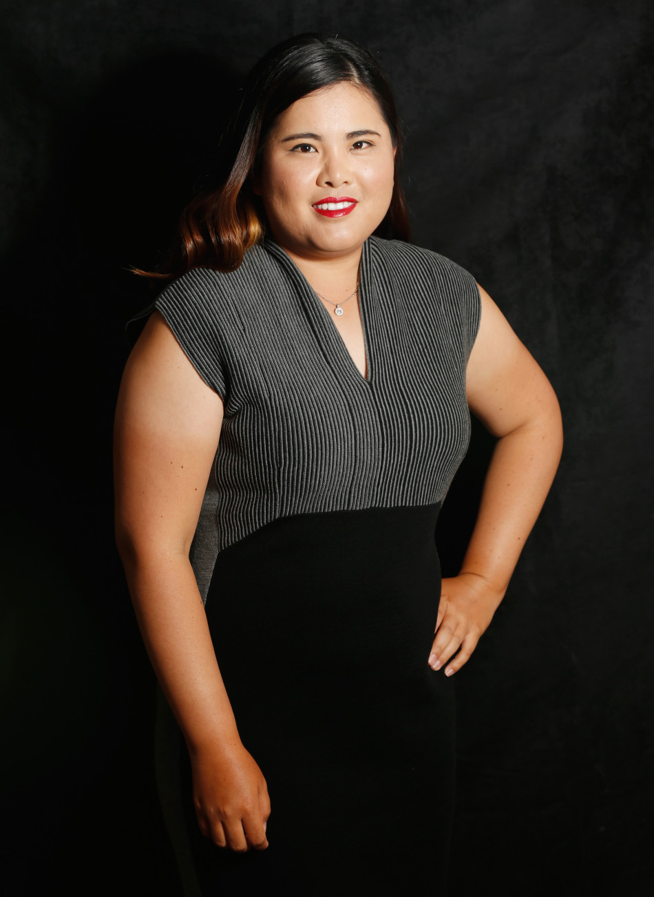 高尔夫球手在果岭边专注地进行切杆练习，阳光洒在草地上映出修长的身影。