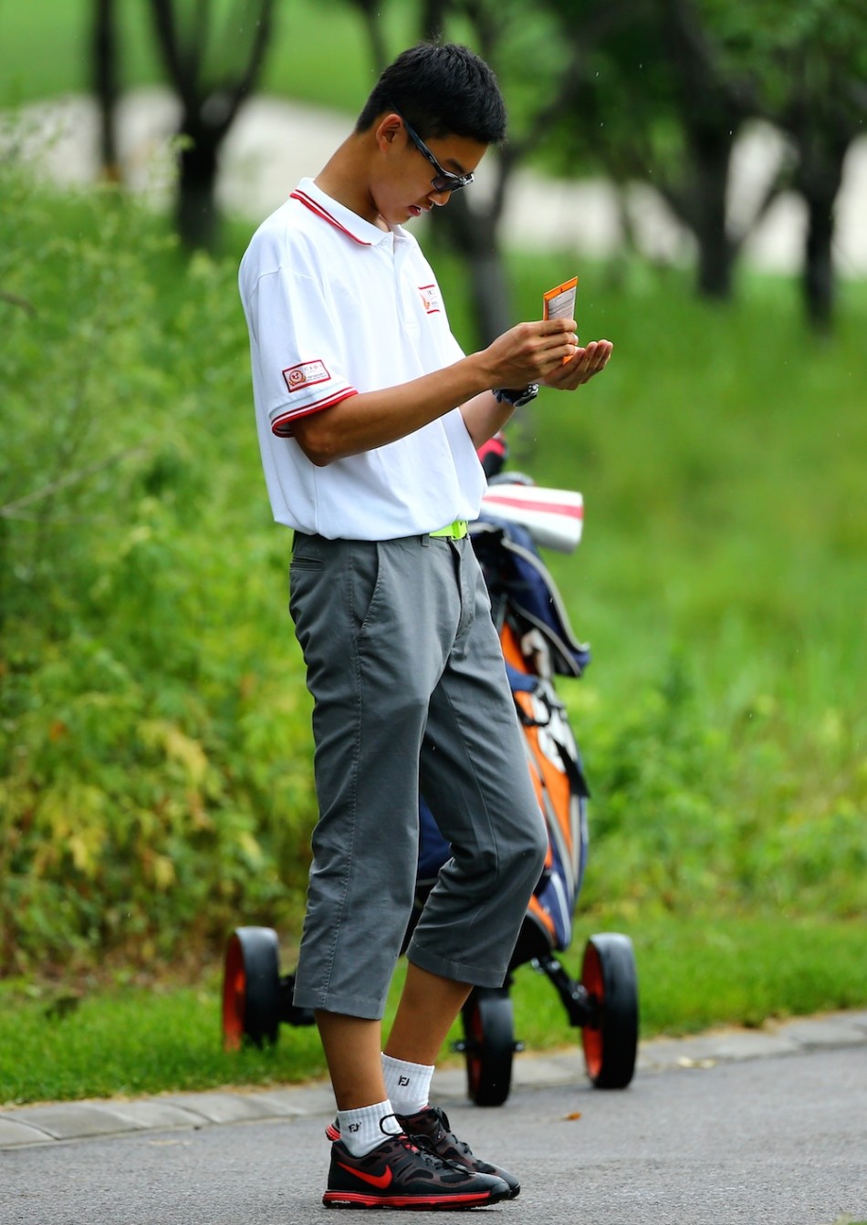 烈日下，一位女选手从容地为手臂涂抹防晒霜，做好持续对抗骄阳的准备。