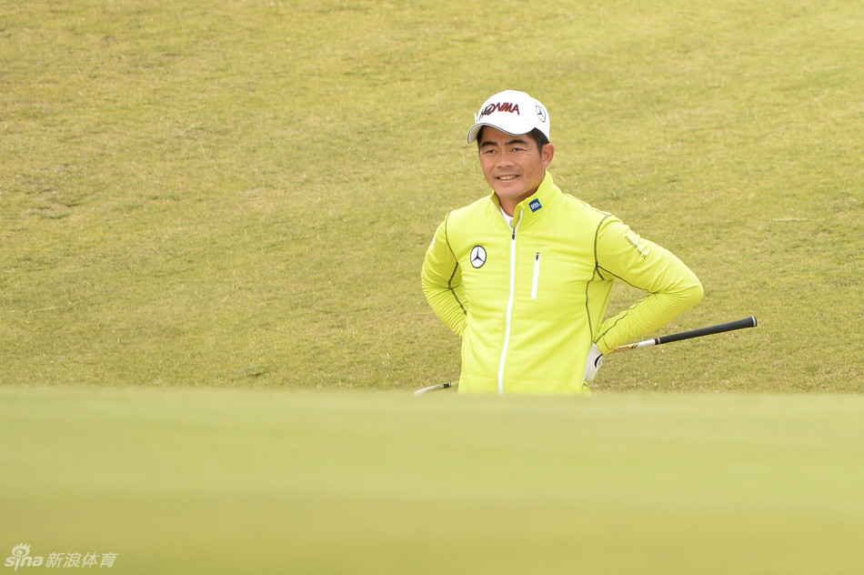 梁文冲于球场高地驻足眺望,海风吹拂衣襟,身影与历史悠久的古老球场构成动人画卷