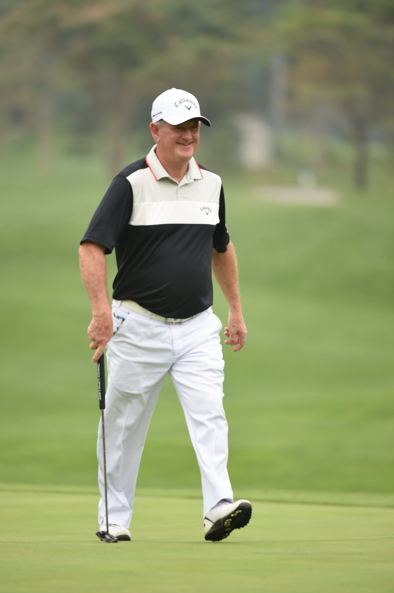 Peter Criss肩扛球杆漫步于球场，姿态悠闲，展现出享受比赛过程的乐观心态。