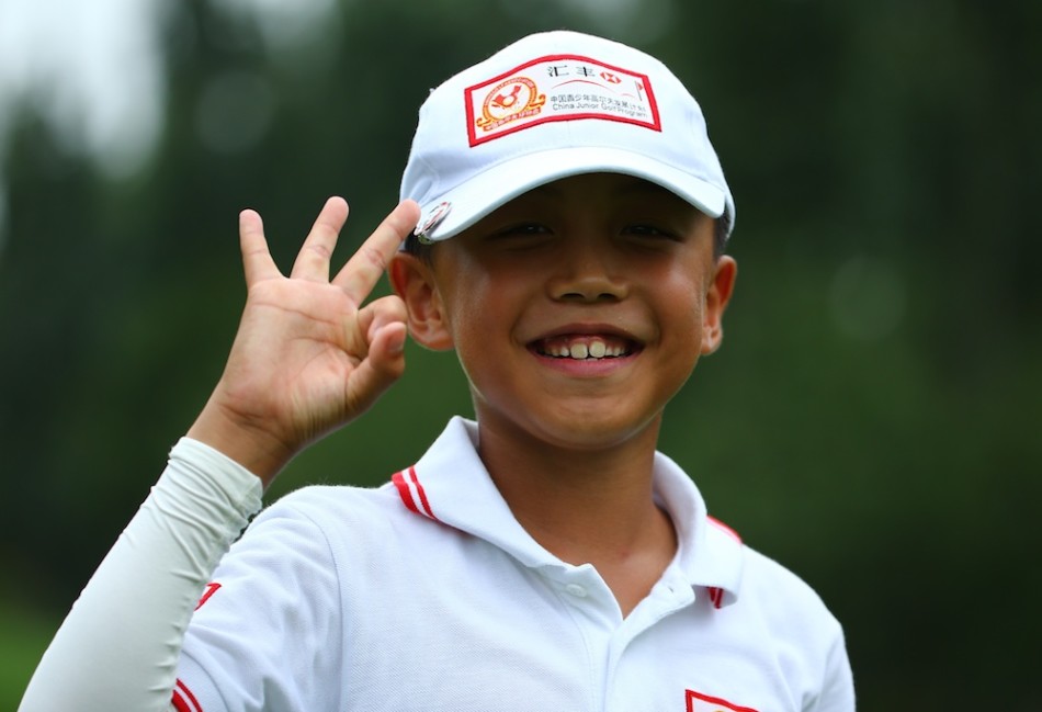 小女孩快乐地奔跑在高尔夫球场上，两条乌黑的辫子随风飞扬起来，充满了无尽的朝气与活力。