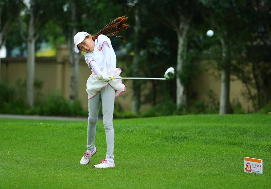 两位青少年球手在休息区轻松交谈，分享着比赛中的趣事，脸上带着愉快的表情。