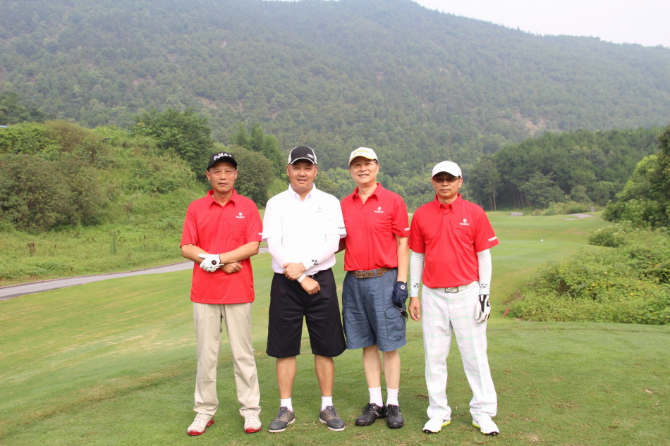 男女球手混合组成的四人小组在发球台开心合影,不同颜色的服装搭配展现出趣味组合的和谐与欢乐氛围。