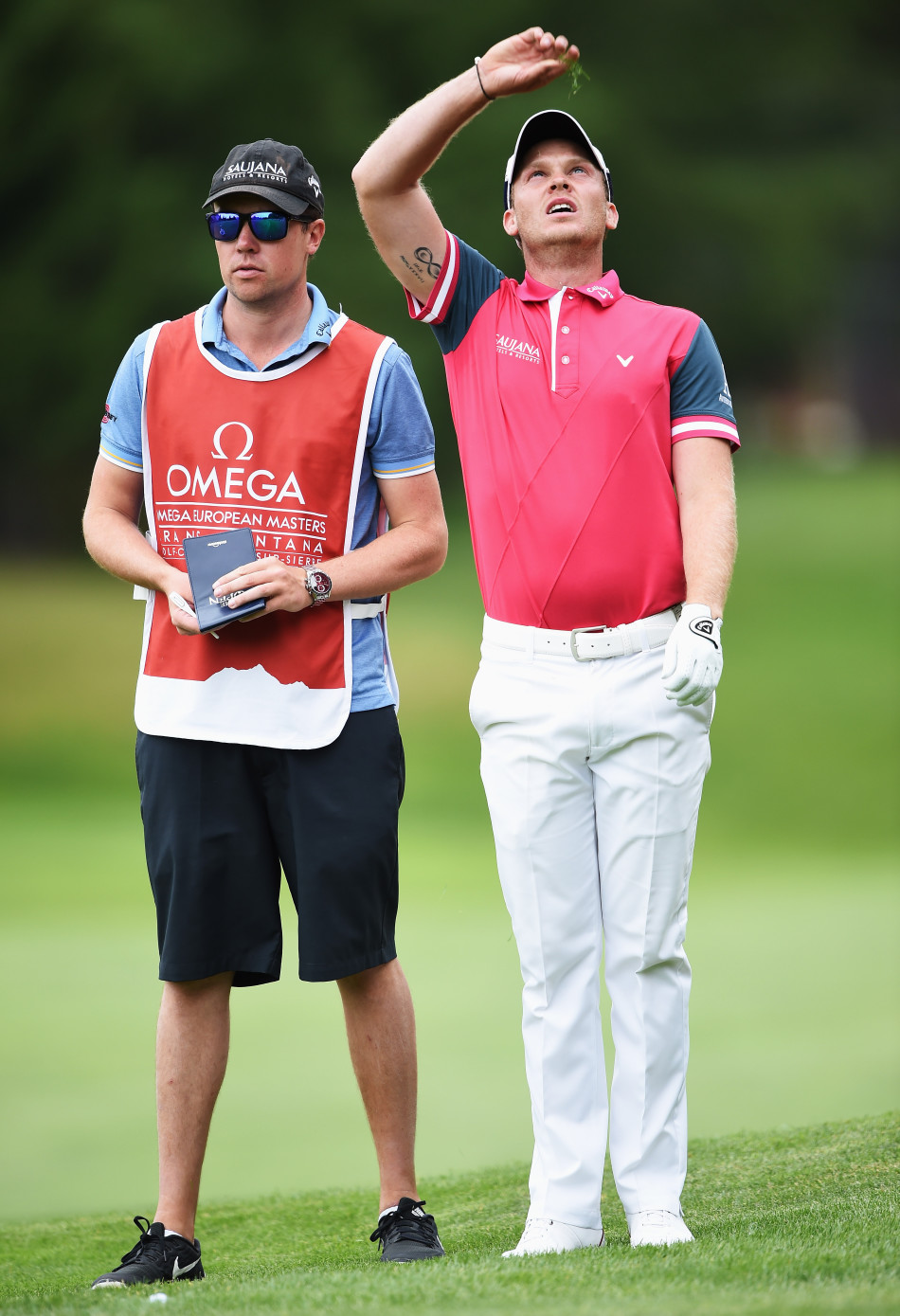 威利特在果岭上俯身，用手指轻轻测试草皮，为至关重要的推杆做最后的信息收集。