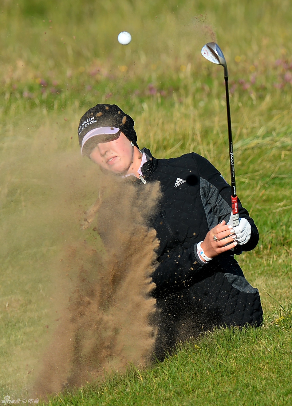 韩国名将金孝周全神贯注，优雅挥杆，白色上衣与球场绿意形成鲜明对比，动作流畅而充满力量。