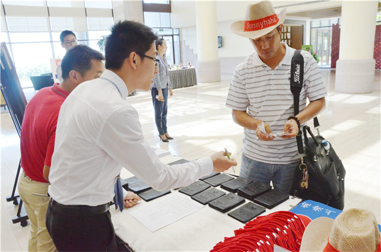 活动现场的趣味游戏区，几位球友正兴致勃勃地尝试推杆进洞游戏，周围观众面露笑容驻足观看。