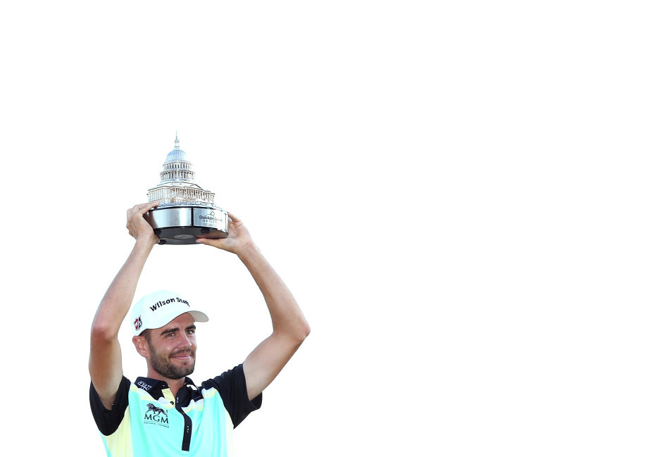 特洛伊·梅瑞特双臂高高举起冠军奖杯，脸上洋溢着无比自豪与喜悦的笑容