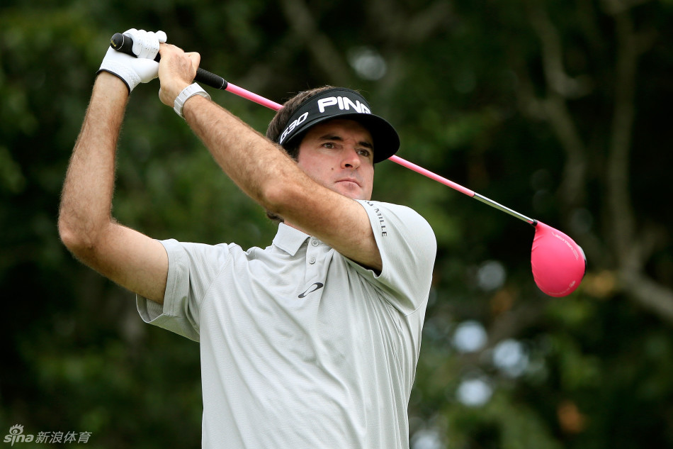 基根·布拉德利站在开球台，双手叉腰陷入沉思，凝望着远方的落球区构思击球策略