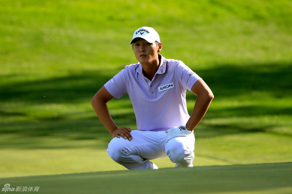 李真明全神贯注地蹲在果岭边，仔细审视小白球与球洞之间草纹的细微变化，寻找最佳的推击线路