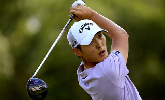 李真明面带微笑走在球道上，首轮领先的战绩让他充满自信，展现出昂扬的竞技状态