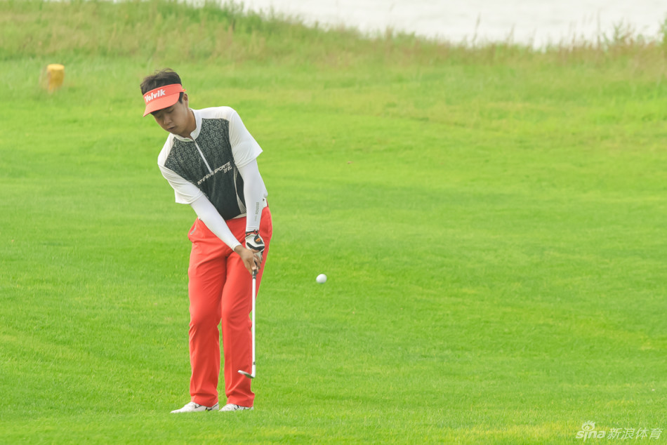 球手在果岭边仔细观察线路,准备进行关键推杆,神情专注,力求一击入洞。