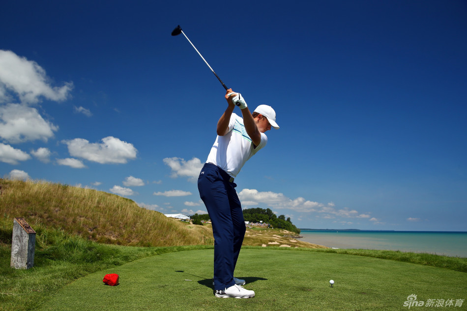 夕阳下，斯皮思在练习场进行温和的收杆练习，动作优雅平衡，仿佛与周围宁静的环境融为一体。