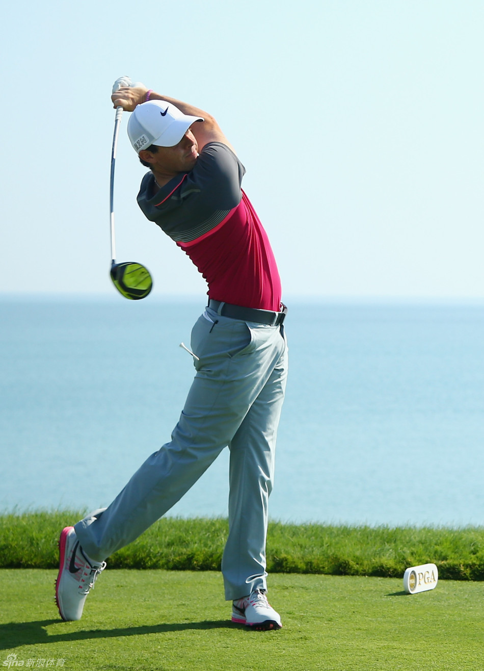 罗里·麦克罗伊在果岭上推入小鸟球后，露出标志性的自信笑容