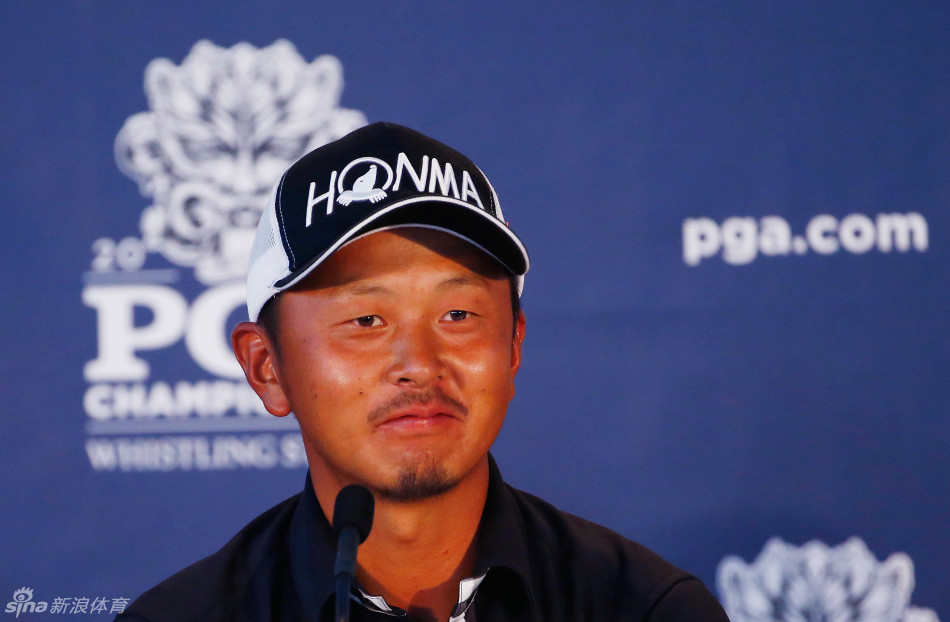 岩田宽在记分处认真核对成绩卡，身旁是赛事官员，他手中的笔正书写下历史性的六十三杆纪录。