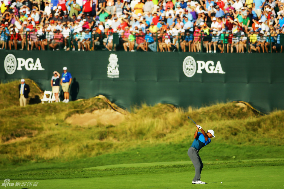 泰格·伍兹蹲在果岭旁，神情极度专注地阅读推杆线路，仿佛正在破解一道关乎胜负的精密谜题。