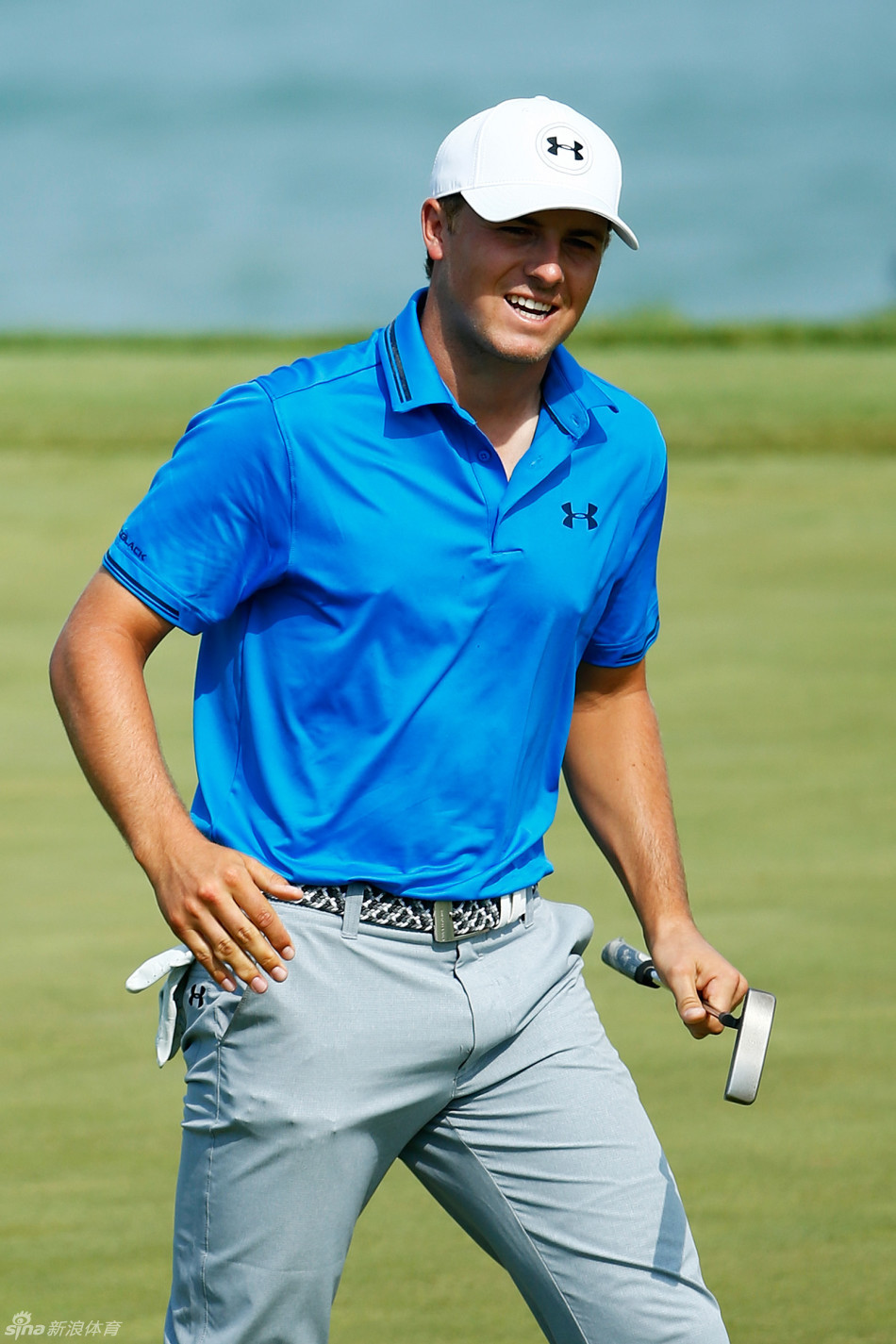 贾斯汀·罗斯在果岭上单膝跪地，聚精会神地观察推击线路，凸显其严谨的赛场态度