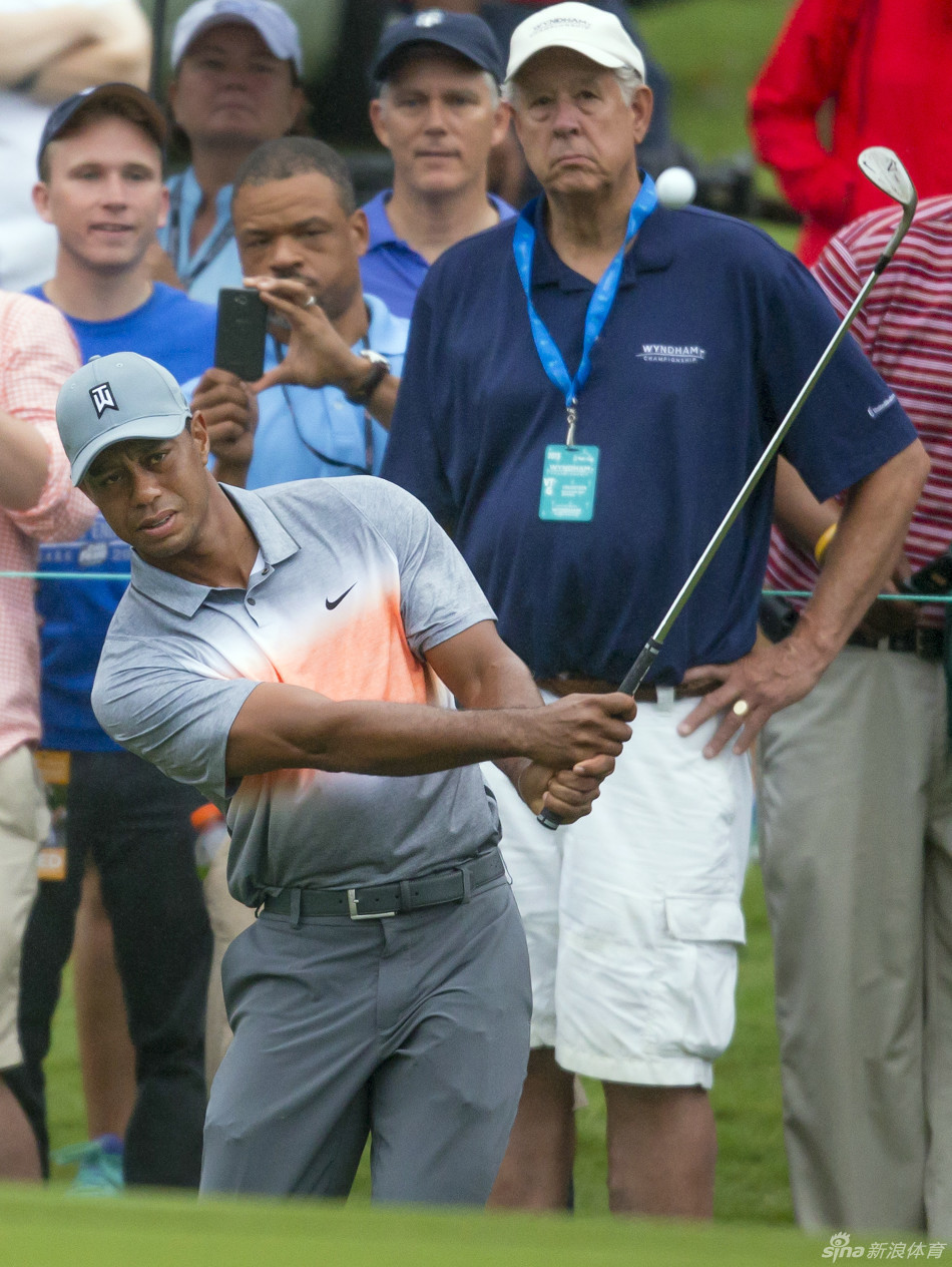 伍兹在果岭边优雅切球，手腕柔和控制，小球轻盈跃向洞杯方向