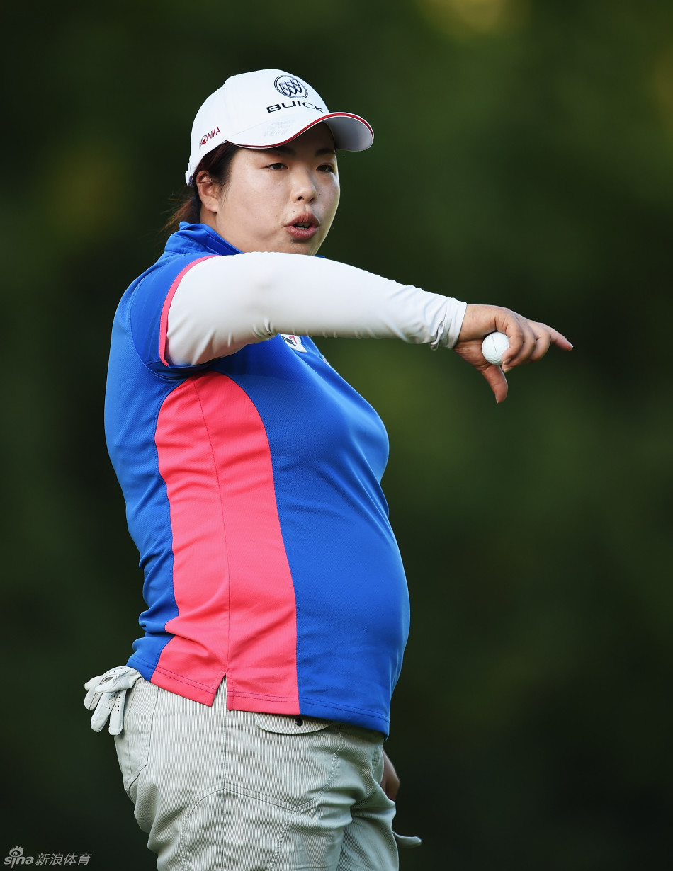 冯珊珊在球场沙坑中练习救球，沙粒飞扬瞬间她保持身体平衡，杆头精准切入沙中，将球送上果岭。