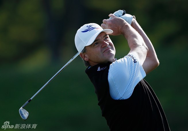 保罗·劳列的中途挥杆瞬间充满动感，草屑随杆头飞起，展现出击球瞬间的力量释放。