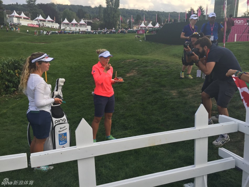 亨德森开心地俯身品尝蛋糕，嘴角洋溢着满足而幸福的微笑。