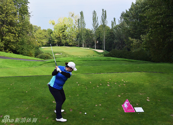 冯珊珊在依云锦标赛开球，清晨的薄雾笼罩着静谧的球场，她全神贯注准备挥杆