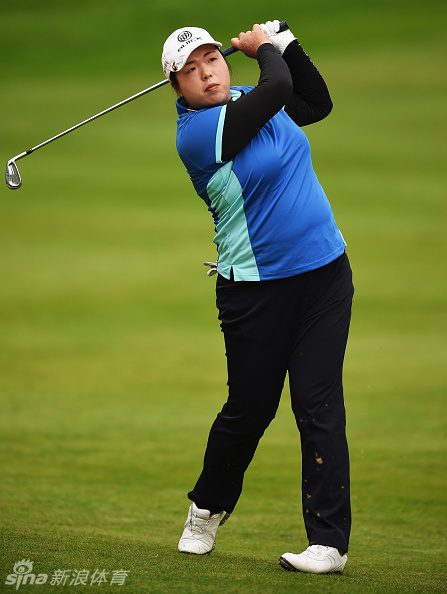 冯珊珊在果岭边仔细摆放小球，眼神专注地评估着眼前的推击线路