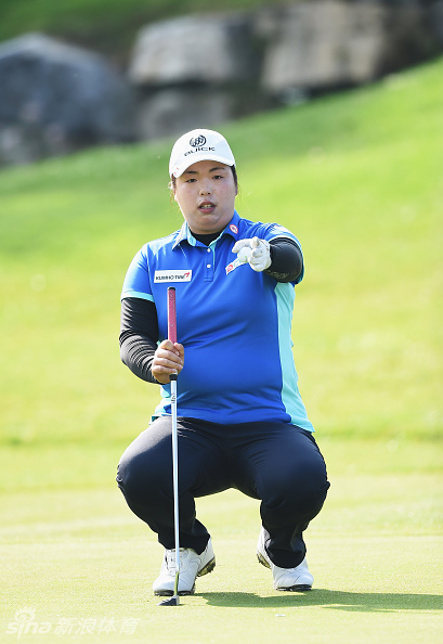 冯珊珊与球童在球道上并肩前行，边走边交流，商讨后续的比赛计划