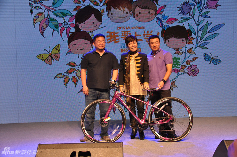 颁奖嘉宾将沉甸甸的奖杯授予获胜者，两人双手紧握奖杯相视而笑，背后大屏幕的爱心logo熠熠生辉