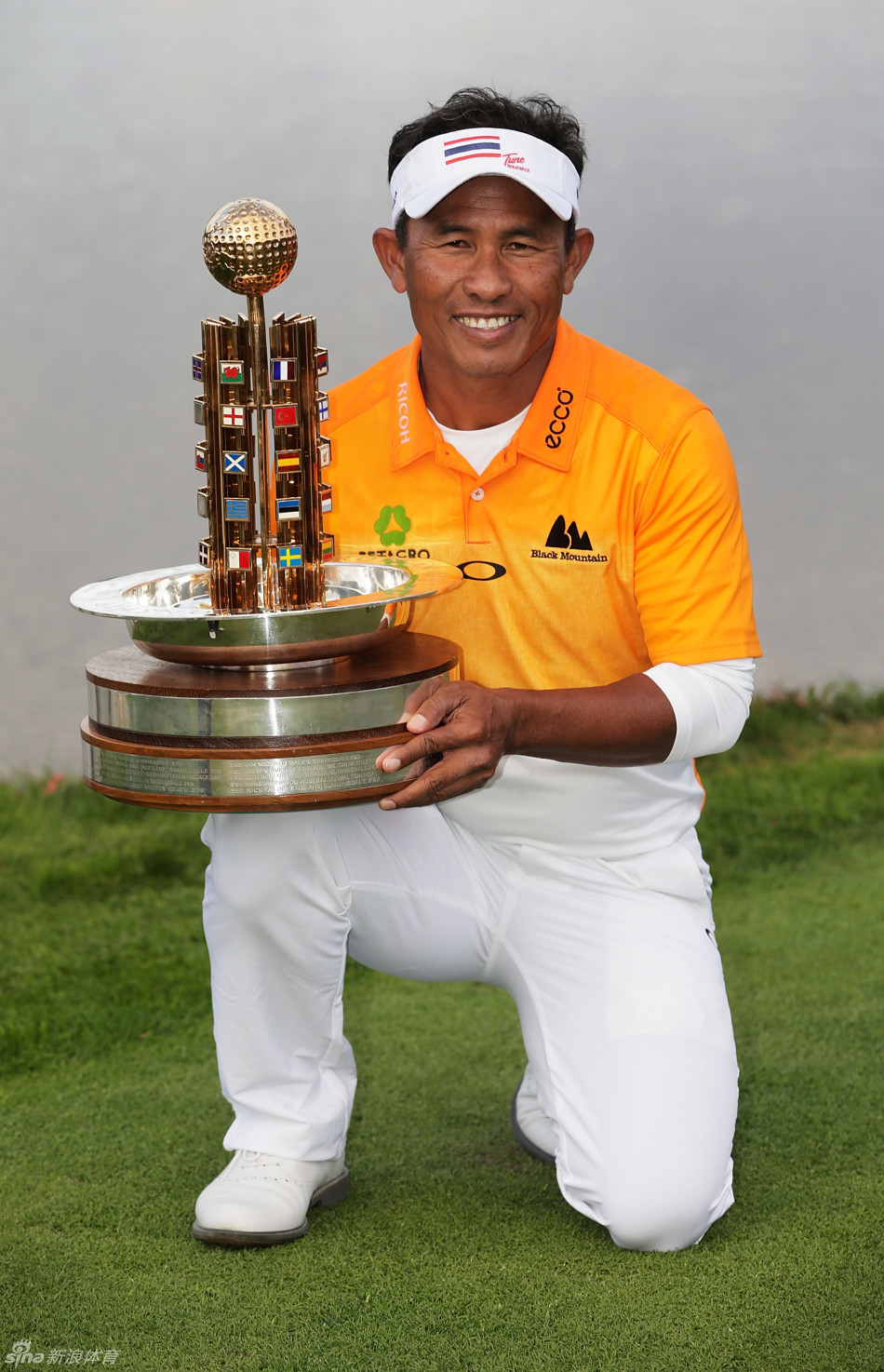 贾第高高举起冠军奖杯，向周围欢呼的观众展示，喜悦之情溢于言表。