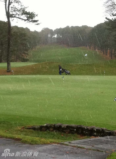 一位身着厚重防寒服的球员在北极光下奋力挥杆，球杆划破极夜寒空
