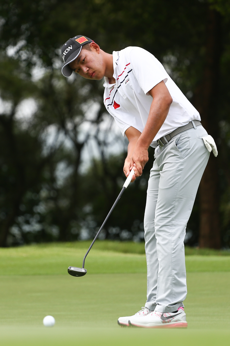 年轻的金诚在果岭边凝神观察，沉稳的姿态完全不像一个十几岁的少年。