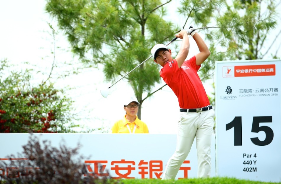 卫冕冠军冈恩在玉龙湾球场果岭边凝神观察，远处群山勾勒出赛场的壮丽轮廓