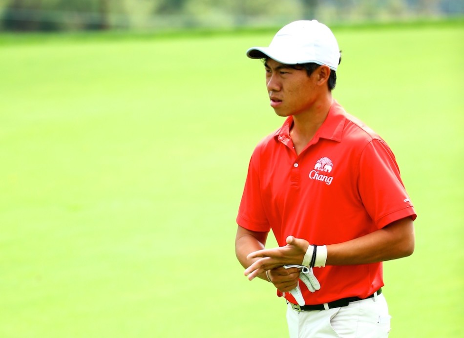 冈恩与球童在球道中密切商讨策略，球场的山地起伏与湖泊障碍清晰可见