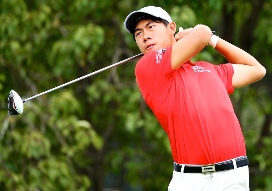 布莱顿·麦克弗森在玉龙湾球场果岭上专注推杆，背景是典型的云南山地森林景观