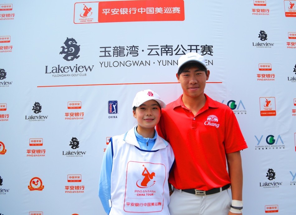 曹一在玉龙湾球场的山坡球位上击球，身体姿态展现出应对陡峭地形的调整与平衡