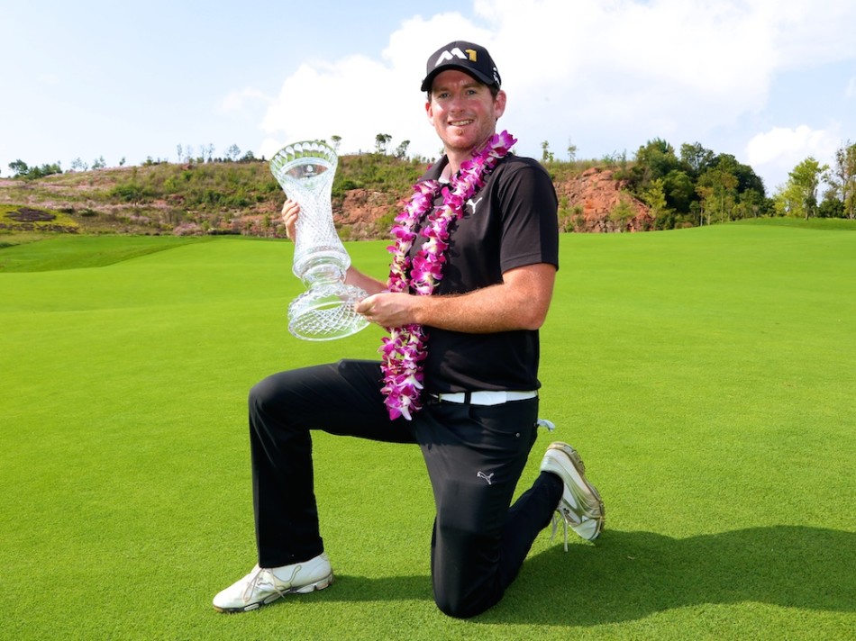 约什·吉里站在第18洞果岭边凝神思考，手扶球杆，微微蹙眉审视着复杂的果岭走势与旗杆位置，争夺冠军的紧张气氛仿佛凝固在空气中。