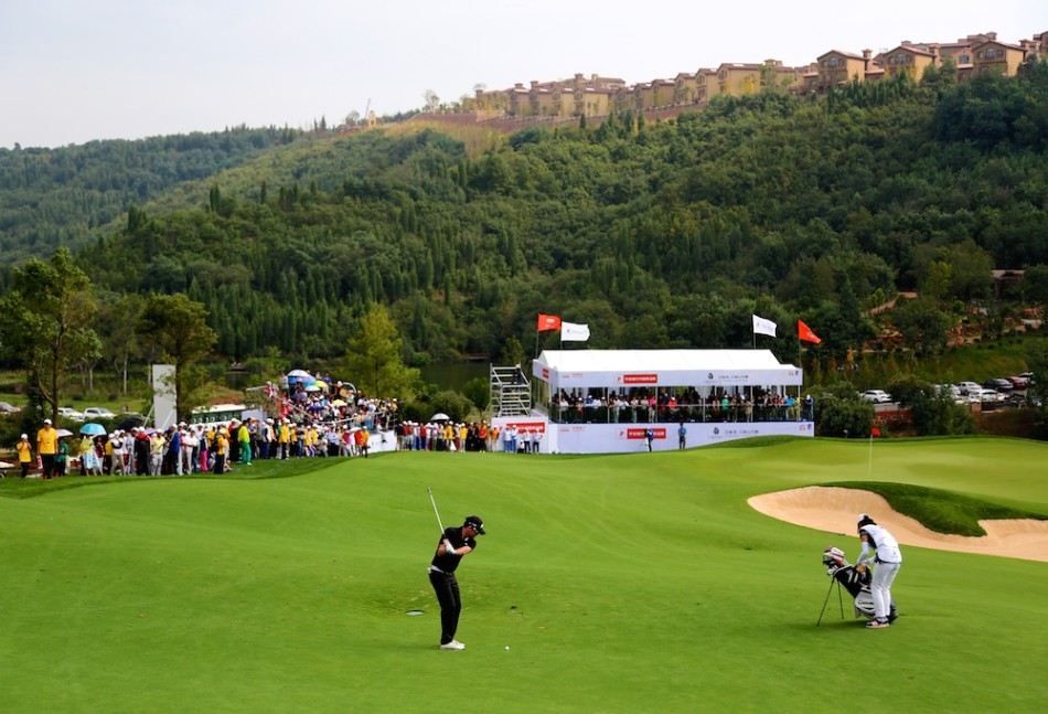 吉里与竞争对手在比赛中友好交流，两人面带微笑，展现了高尔夫运动尊重与友谊并存的绅士精神。