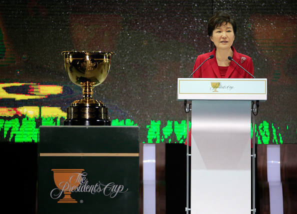 美国总统队队员面带自信笑容,在团队旗帜下展现出卫冕冠军的团结与气势。