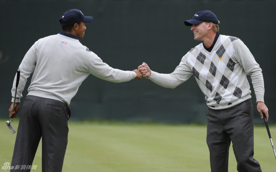 一名国际队球员在沙坑中奋力救球，沙粒飞溅，瞬间捕捉了高尔夫运动中力量、技巧与逆境求胜的完美结合。