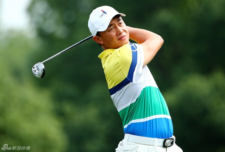 庐山公开赛发球台标志特写，金属TEE标在绿草地上熠熠生辉，背景是朦胧的远山