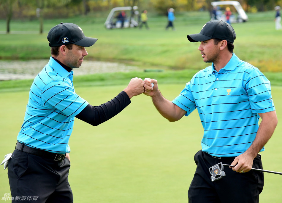 简森·戴伊与乔丹·斯皮思在比赛中同组竞技,两人在果岭上仔细查看推杆线路,表情专注严肃,一场世界顶级的个人对决正在上演。