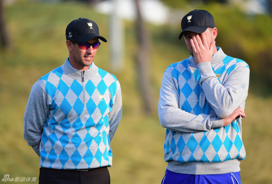 国际队队员集体走向球场的背影,他们身着统一的格子队服,在广阔的球场与天空背景下,构成了一幅充满决心与团队力量的动人画面。