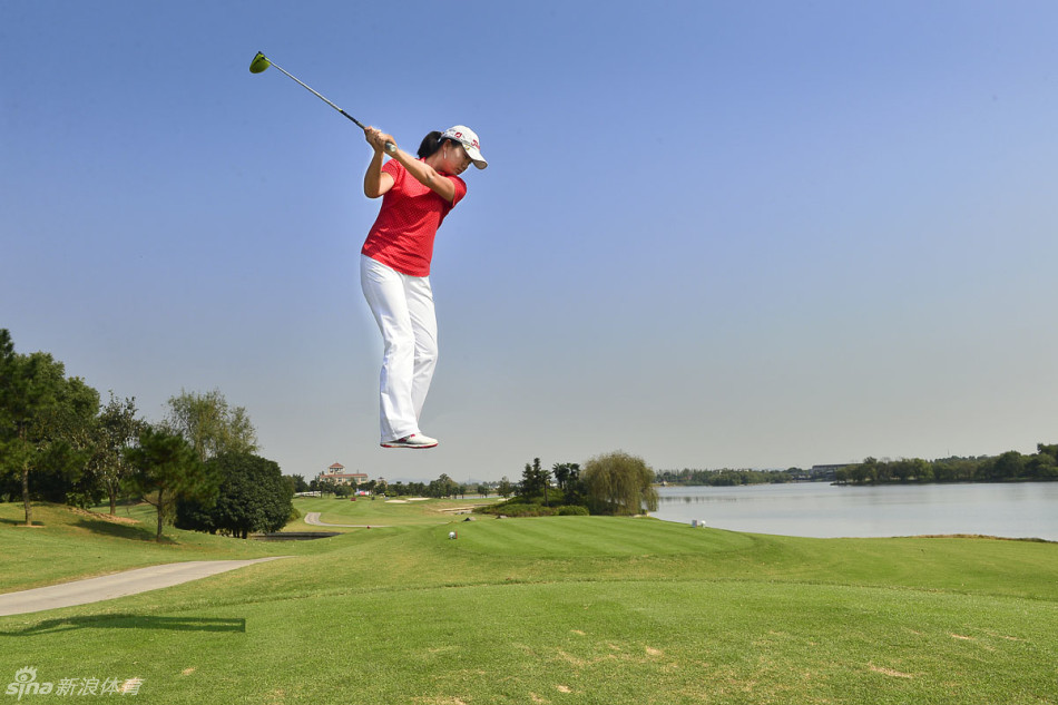 冠军球员举起奖杯瞬间，笑容灿烂与身后蓝天绿草相映成辉