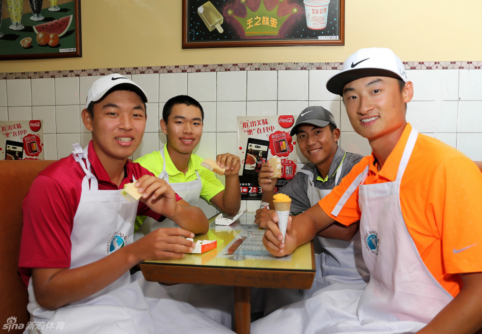 金诚与潘政琮小心翼翼地尝试亲手包装雪糕三文治,动作略显生疏却十分认真,与身旁老师傅熟练的姿态形成有趣对比。